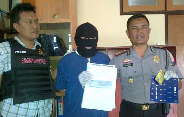 Pelaku menggunakan penutup muka dan uang sisa penggelapan yang diamankan polisi. foto: rusmiyanto/BANGSAONLINE