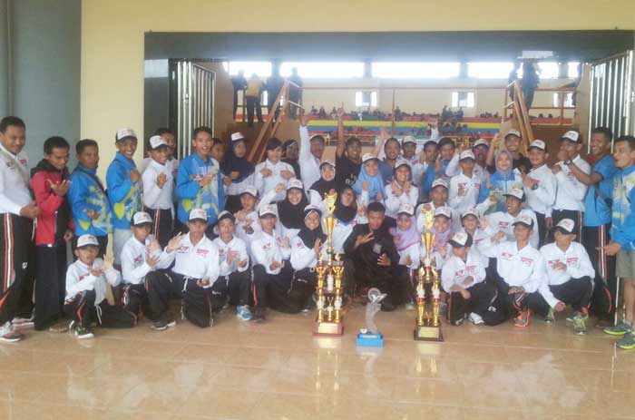 Para atlet berpose bersama trofi.