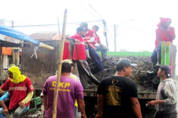 Petugas DKP saat membersihkan drainase untuk dilakukan normalisasi. foto: arif kurniawan/BANGSAONLINE