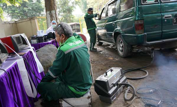 Petugas saat memeriksa emisi salah sati kendaraan. foto: rony suhartomo/BANGSAONLINE