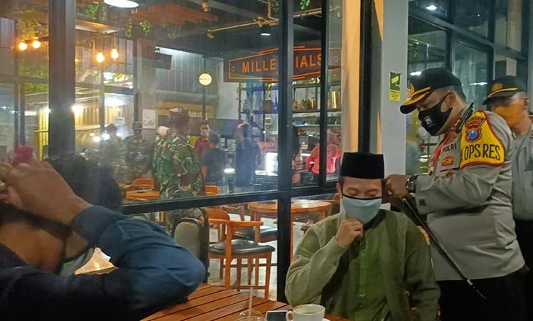 AKBP Rama Samtama Putra, Kapolres Bangkalan saat memasangkan masker secara langsung kepada pengunjung di salah satu kafe, Sabtu (4/7/2020) malam.