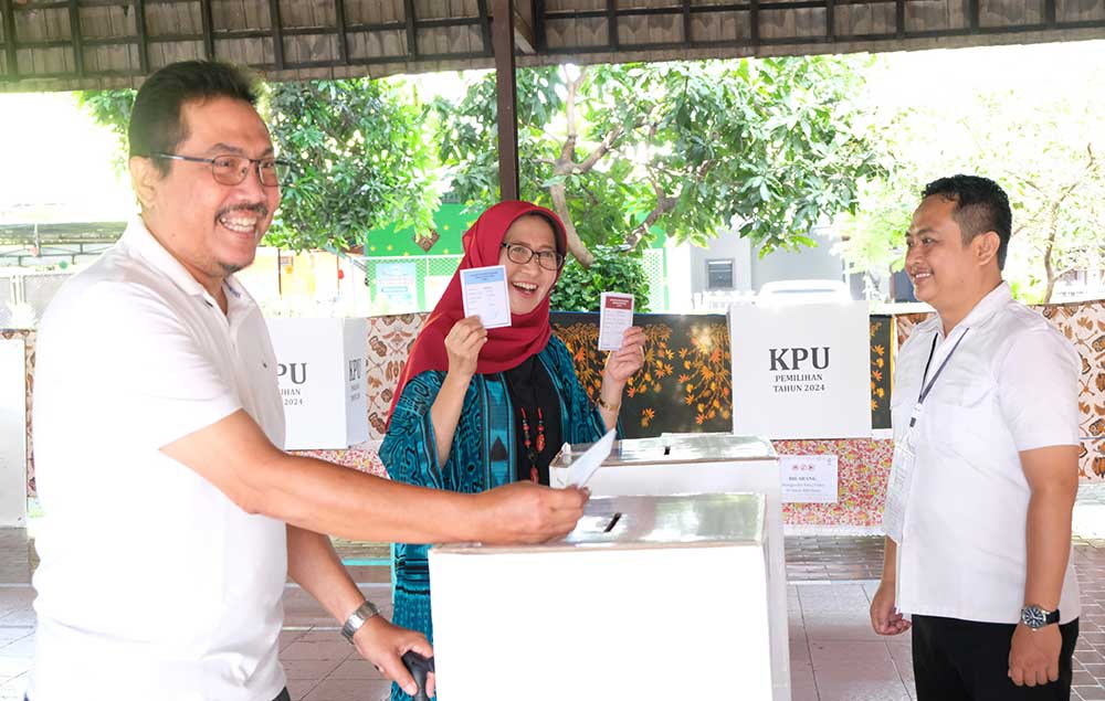 Bunda Indah menggunakan hak pilihnya di TPS 14 bersama suami. Foto: IMRON GHOZALI/ BANGSAONLINE