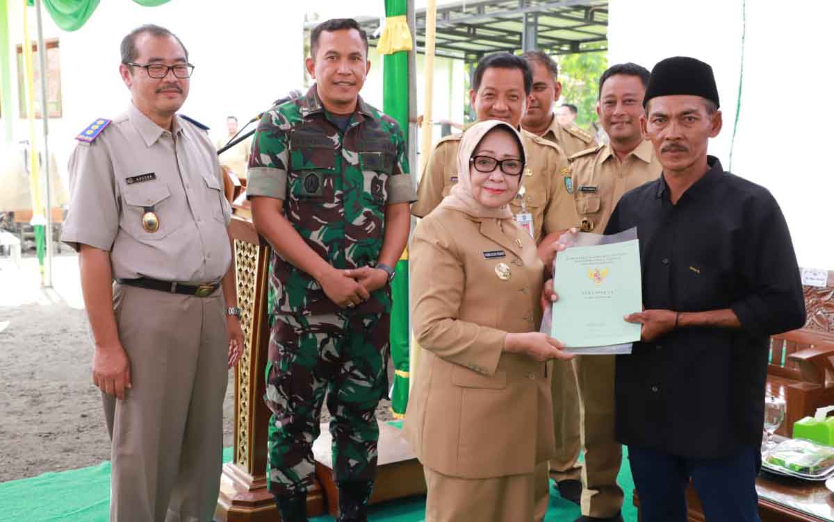Bupati Jombang, Mundjidah Wahab, saat menyerahkan secara simbolis sertifikat tanah dari program PTSL untuk salah satu warga di Desa Kabonagung.