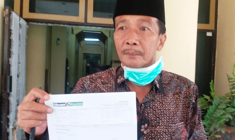 Hosyan Muhammad menunjukkan hasil swab/PCR dari Hospital Siloam Surabaya saat konferensi pers di gedung DPRD Bangkalan, Kamis (30/4).