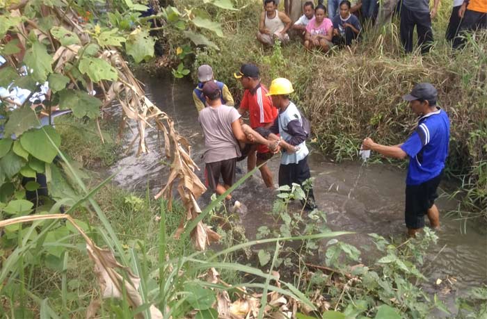 Petugas dibantu warga saat mengevakuasi mayat korban.