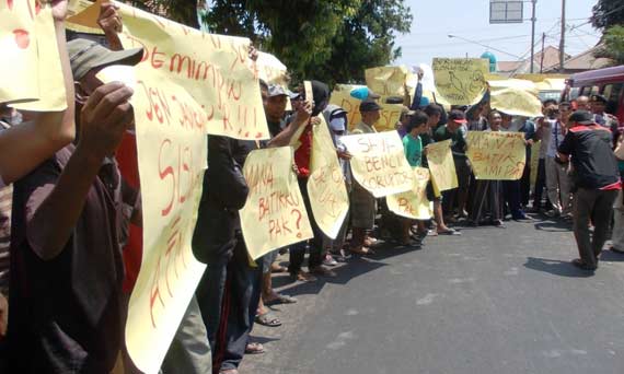 Ratusan massa membentangkan sejumlah poster saat Demo di depan Kantor Dispendik. foto: hadi prayitno/BANGSAONLINE