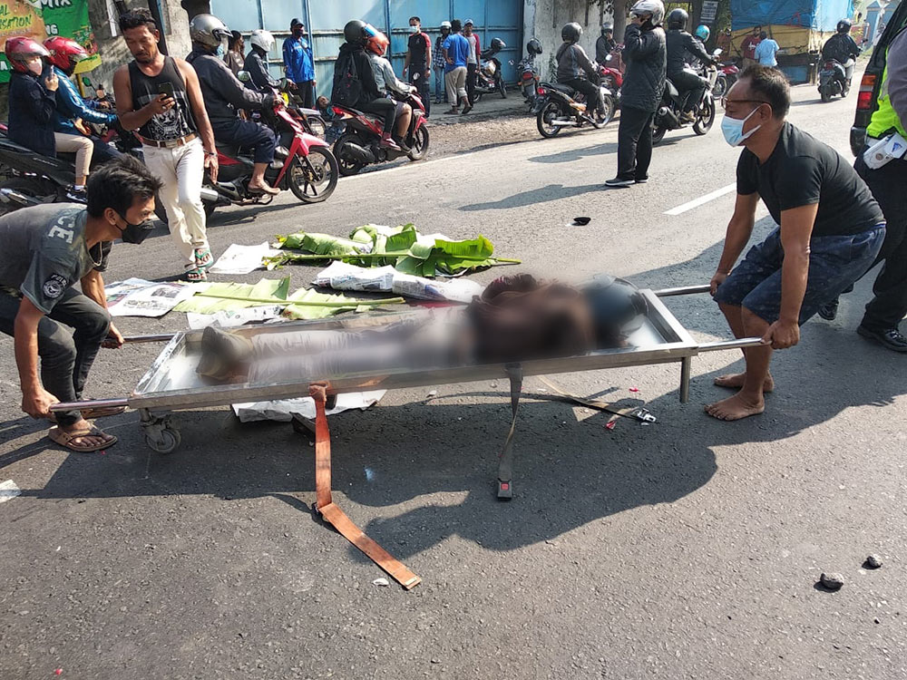 Korban kecelakaan di Sidoarjo yang ditandu oleh warga.