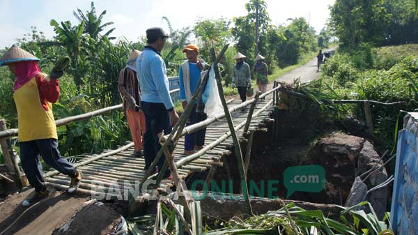SEMENTARA: Warga gotong royong membuat jembatan alternatif dari bambu. foto: rony suhartomo/ BANGSAONLINE