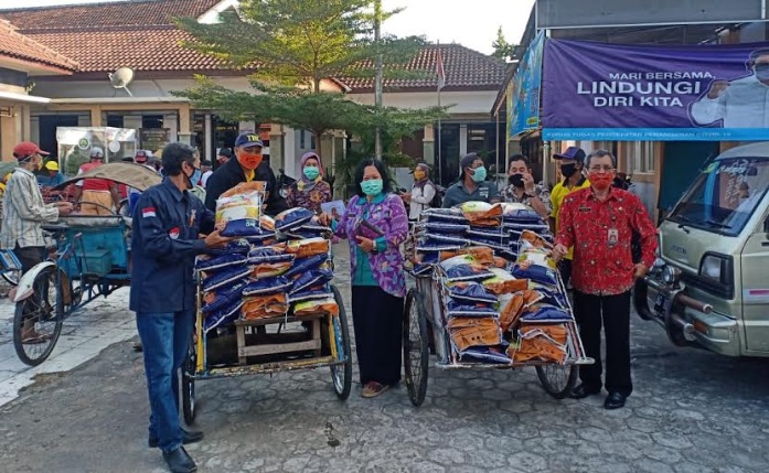 Lurah Pojok Erly Maya Muryati, bersama Abang Becak yang akan mengantarkan sembako. 