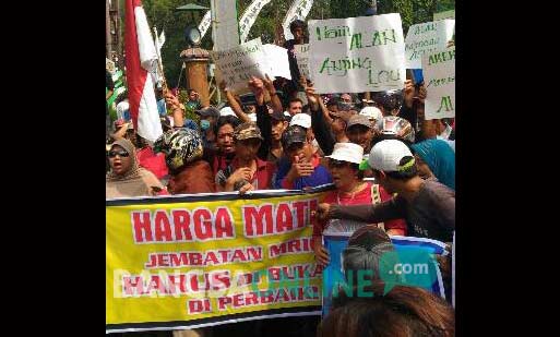 Ratusan massa saat berkumpul di areal lokasi jembatan Mrican, yang akhirnya resmi dibuka setelah 4 bulan ditutup. foto: arif kurniawan/ BANGSAONLINE