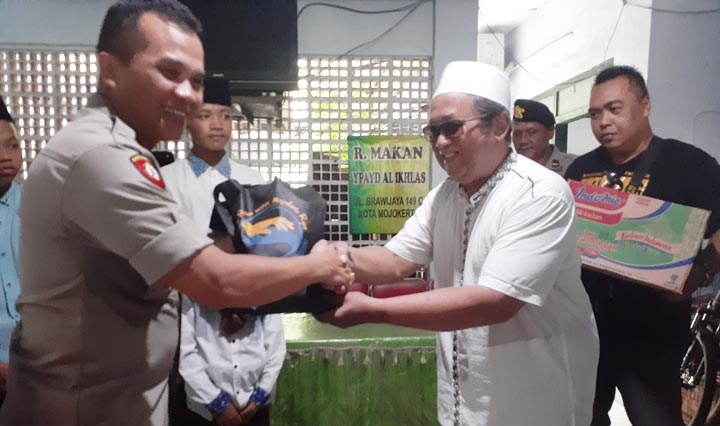 Kapolres Mojokerto Kota didampingi Ketua Panitia HPN dan Ketua PWI, secara simbolis menyerahkan santunan.