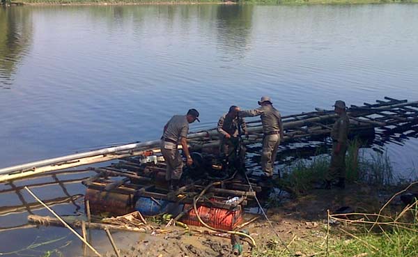 RAZIA: Tampak petugas polisi dan Satpol PP sedang melakukan razia penambang pasir ilegal dengan mekanik di Sungai Bengawan Solo beberapa waktu lalu. foto: eky nurhadi/BANGSAONLINE