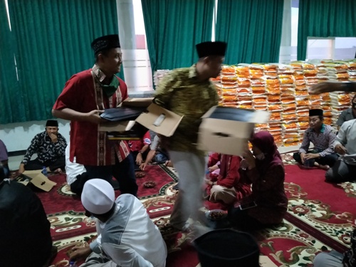 Para relawan penanganan Covid-19 Mojokerto Jawa Timur saat membagikan sarung dan beras sedekah Prof. Dr. KH. Asep Saifuddin Chalim, M.Ag di Guest House kampus Institut KH Abdul Chalim Pacet Mojokerto Jawa Timur, Jumat (15/5/2020). foto: MMA/bangsaonline.com 