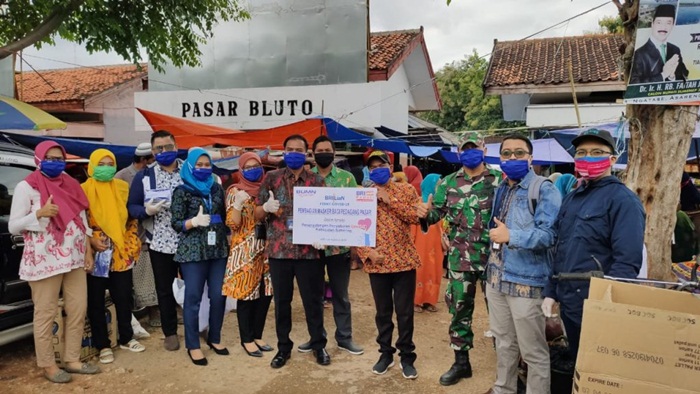 Babinsa Koramil Bluto bersama BRI sedang membagikan masker gratis ke pedagang pasar.