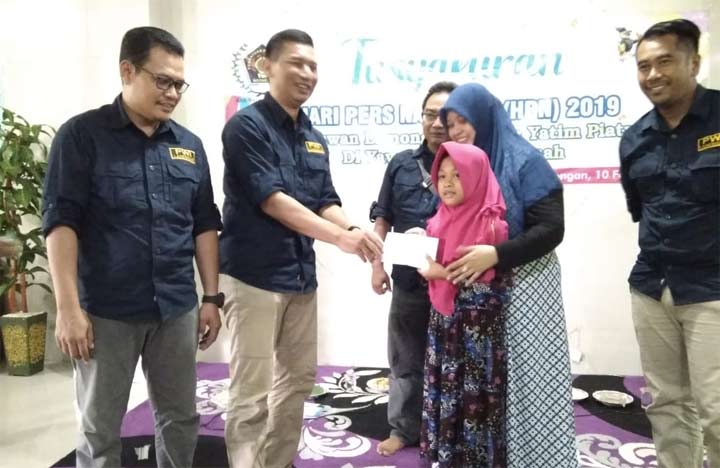 Ketua PWI Kabupaten Lamongan, Bachtiar Febriyanto menyerahkan santunan kepada anak yatim.