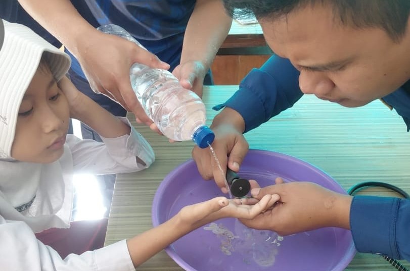Petugas Damkar saat melepas cicin yang tersangkut di jari siswi SD. (Ist)