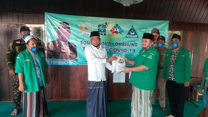 H. Syafiuddin Asmoro menyerahkan secara simbolis bantuan sembako kepada Ketua GP Ansor H. Hasani Zubair.