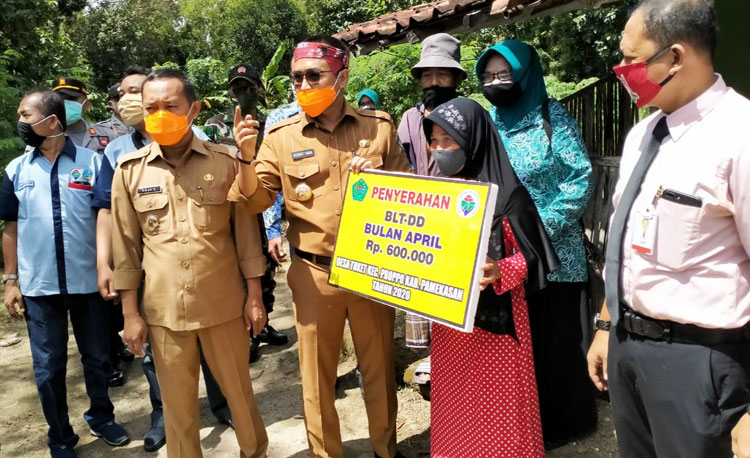 Bupati Pamekasan Baddrut Tamam saat menyerahkan BLT di salah satu rumah warga di Dusun Timur, Desa Toket, Kecamatan Proppo, Kabupaten Pamekasan. 