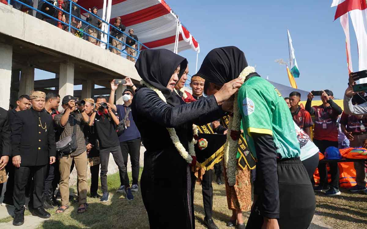 Bupati Mojokerto, Ikfina Fahmawati, saat mengalungkan bunga pada seorang atlet dayung putri.