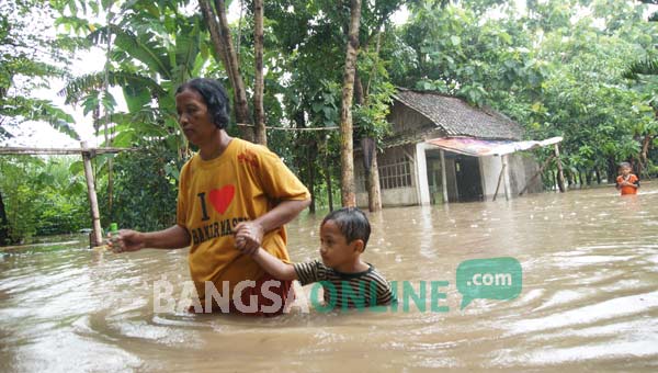 Seorang warga bersama anaknya saat hendak mengungsi. foto: rony suhartomo/ BANGSAONLINE