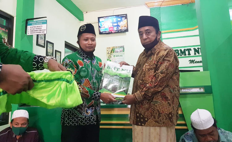 KH. Drs. M. Jamhuri, Wakil Ketua MWC NU saat menyerahkan santunan secara simbolis.