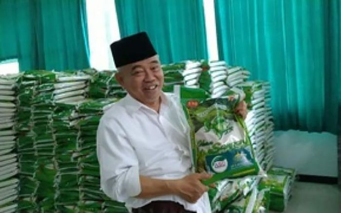 Prof. Dr. KH. Asep Saifuddin Chalim, M.A., menunjukkan beras yang dibagikan kepada masyarakat. Beras itu diberi label ASC Foundation, lembaga nirlaba yang punya misi: hanya memberi untuk berbagi, tidak menerima bantuan dari pihak manapun. Beras itu dibeli Kiai Asep dari uang pribadi. Foto: m. mas