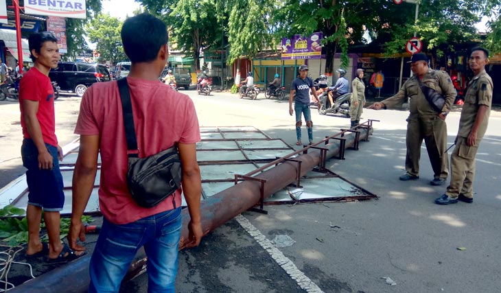 Penertiban tiang reklame bodong di jalan Mojopahit Selatan. Dispol PP menargetkan merobohkan puluhan tiang reklame ilegal yang habis masa izinnya. foto: YUDI EP/ BANGSAONLINE