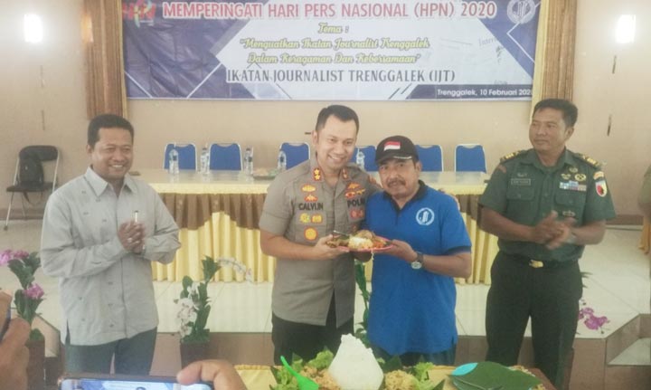 Kapolres Trenggalek saat potong tumpeng di acara Peringatan Hari Pers Nasional yang digelar IJT di BBI Trenggalek. foto: HERMAN/ BANGSAONLINE