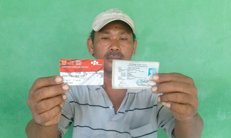 Samsul Aripin menunjukkan Kartu Keluarga Sejahtera (KKS) miliknya.