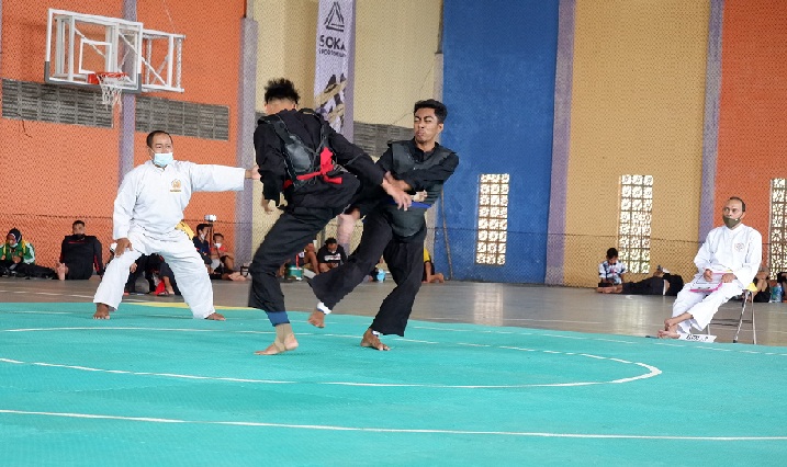 Atlet pencak silat kategori tanding putra sedang bertarung di Gedung Soka Perumahan Griya Utama Bangkalan, Sabtu (2/10/2021). foto: FAUZI/ BANGSAONLINE