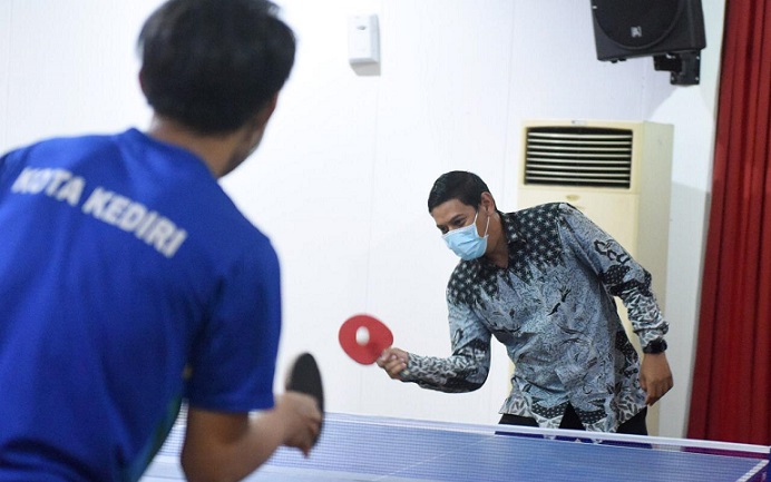 Wali Kota Kediri Abdullah Abu Bakar saat latih tanding dengan salah satu atlet tenis meja andalan kota Kediri. (foto: ist.)
