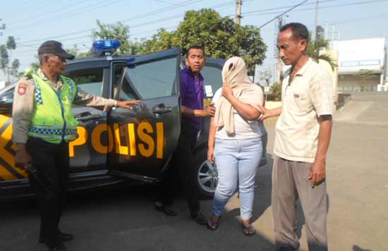 IMITASI. Tersangka Silvi Widiasari menutupi wajahnya ketika digelandang  petugas ke Polsek Porong. foto: catur andy/BANGSAONLINE