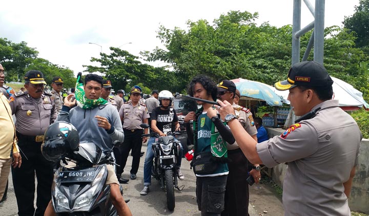 Kapolres Bangkalan AKBP Rama Samtama Putra meminta salah satu Bonek asal Kamal untuk memakai helm. foto: AHMAD FAUZI/ BANGSAONLINE