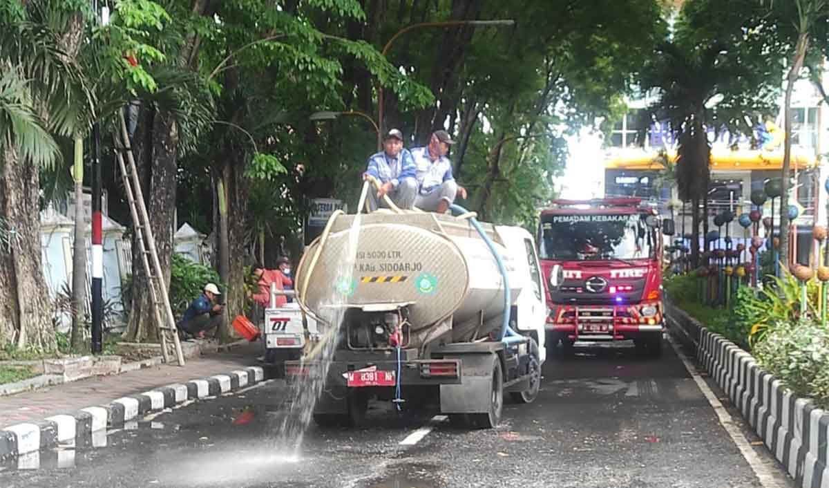 Petugas DLHK Sidoarjo saat membersihkan sampah pascademo di pendopo bupati. Foto: Ist
