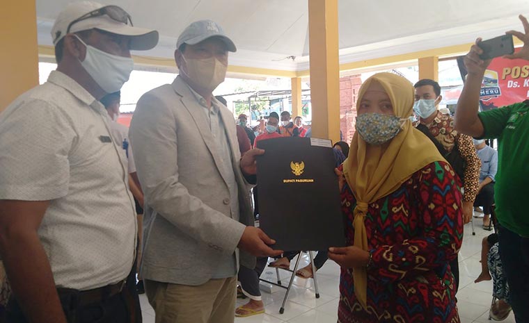 Bupati Pasuruan H. M. Irsyad Yusuf (dua dari kiri) saat menyerahkan bantuan untuk korban banjir bertempat di Balai Desa Kepulungan, Jum