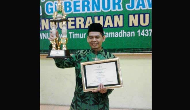 Sekretaris PCNU Magetan Ahmad Sudarto SPdI mengangkat piala dan piagam NU Award Jatim. foto istimewa