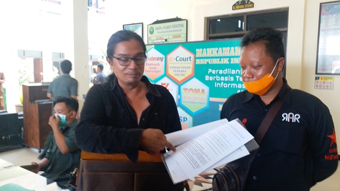Risang Bima Wijaya menunjukkan surat tertulis di sidang mediasi kepada media.