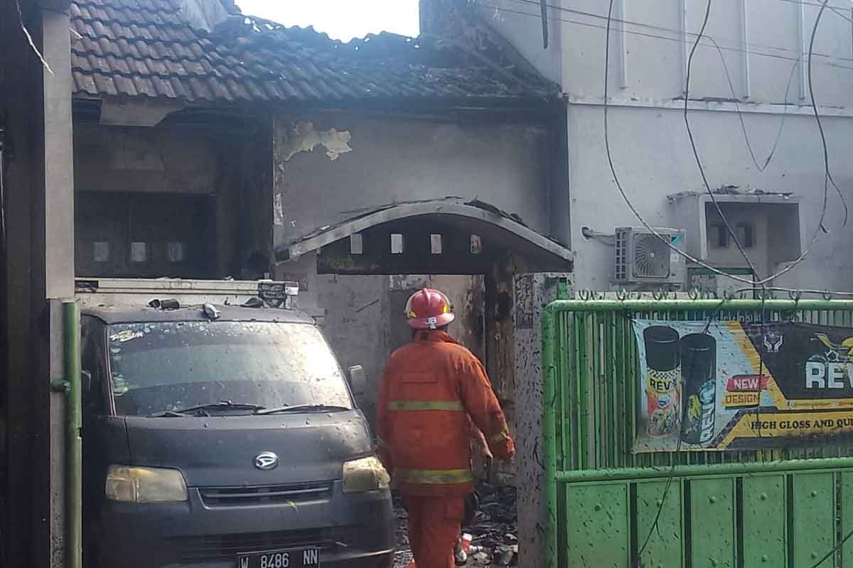 Petugas pemadam kebakaran saat melakukan pembasahan di gudang cat Sidoarjo.