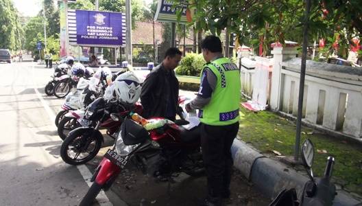Pengendara menunggu polisi yang memroses surat tilang. foto: roni suhartomo/ BANGSAONLINE