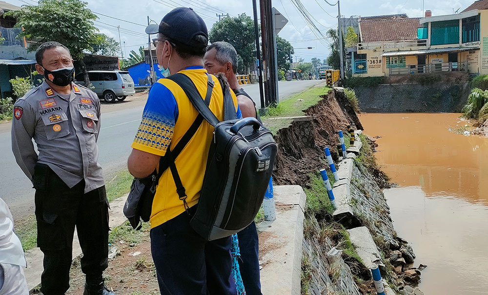 Kapolsek Banyakan AKP Wahana (kiri) bersama tim dari BBWS Brantas Kediri saat mengecek kondisi tanggul Sungai Bendokrosok yang ambrol. foto: MUJI HARJITA/ BANGSAONLINE