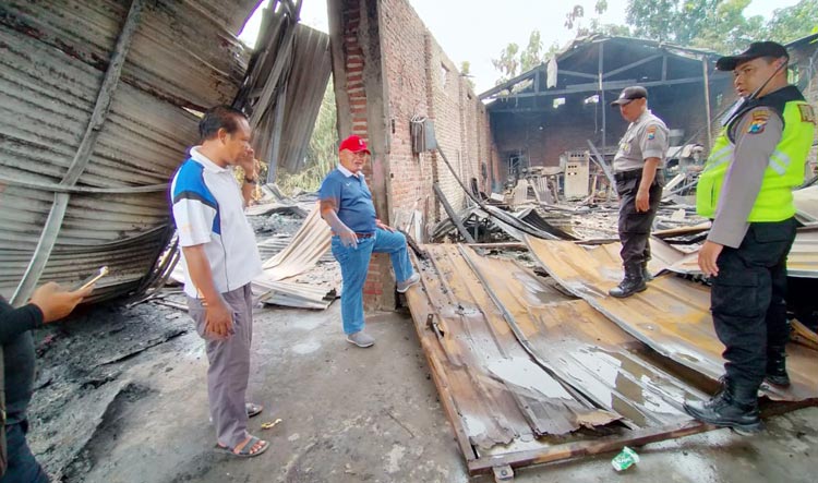 Kapolsek Krembung AKP Purwanto (topi merah) saat meninjau lokasi gudang plastik yang terbakar.