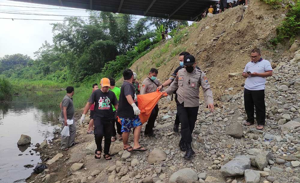 Petugas saat mengevakuasi jasad korban yang ditemukan di bawah Jembatan Trisula, Kademangan, Blitar.