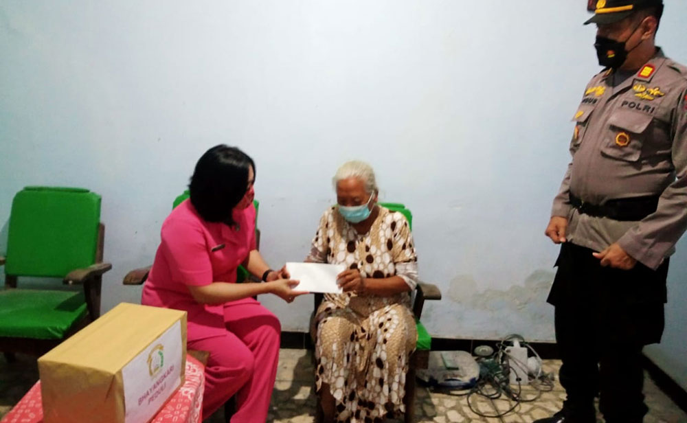 Kapolsek AKP Agus Sudarjanto bersama istrinya saat memberikan bantuan kepada Mbah Poninten. foto: ist. 