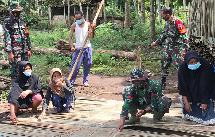 Satgas TMMD ke-110 Jember sedang membantu para perajin kerai bambu.