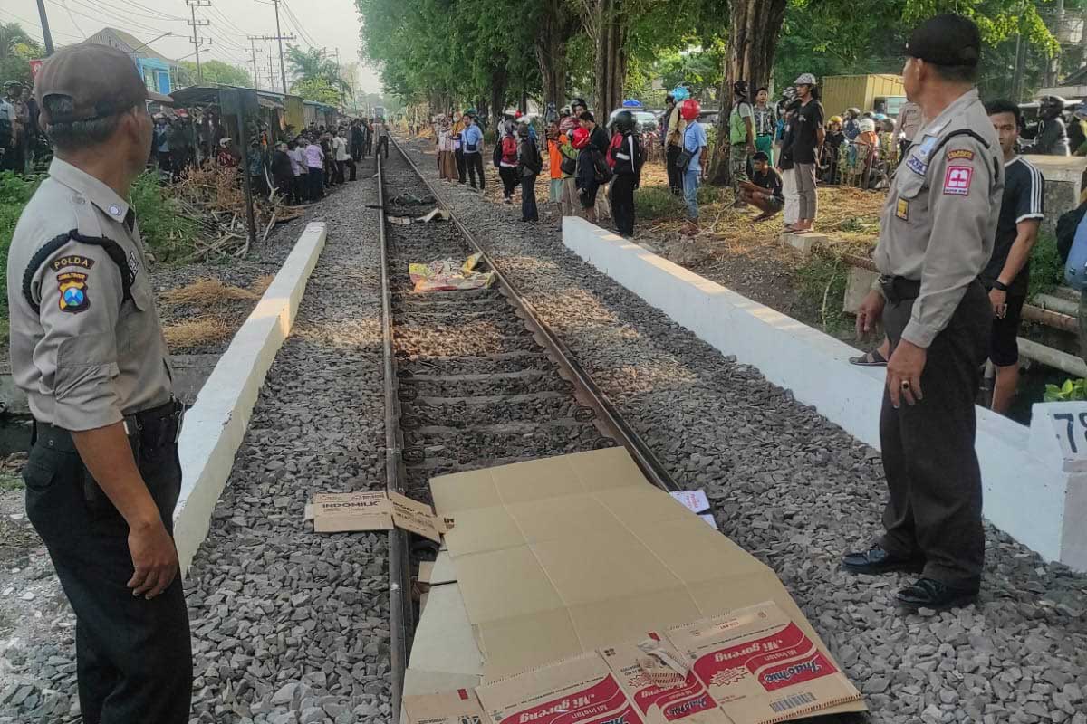 Korban tertabrak kereta api di Maspion IIII Gedangan, ditutupi kardus oleh warga sekitar sebelum dilakukan evakuasi.
